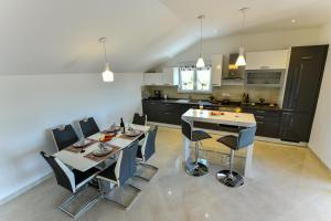 a kitchen with a table and chairs in a room at CAMBI LUX APARTMENT in Otok