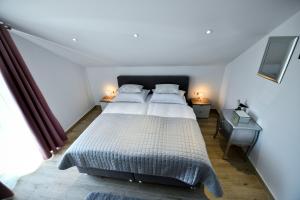 a bedroom with a large bed and two night stands at CAMBI LUX APARTMENT in Otok +42 photos