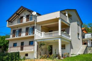 an apartment building with balconies and a blue sky at CAMBI LUX APARTMENT in Otok