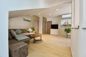 a living room with a couch and a tv at CAMBI LUX APARTMENT in Otok