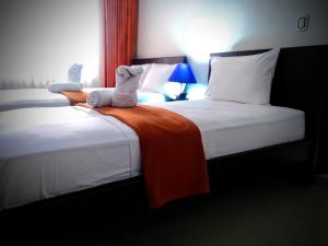 2 camas en una habitación de hotel con un animal de peluche en la cama en Hotel Casimena en Yopal