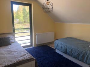 a bedroom with a bed and a large window at Lakehouse Nakielno in Wałcz