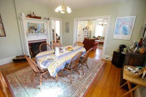 a dining room with a table with chairs and a fireplace at A Village Bed and Breakfast in Newton