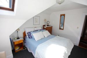 a bedroom with a bed with blue and white pillows at A Village Bed and Breakfast in Newton