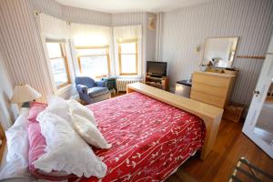 ein Schlafzimmer mit einem großen Bett mit einer roten Decke in der Unterkunft A Village Bed and Breakfast in Newton