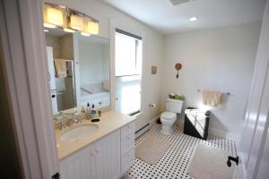 a white bathroom with a sink and a toilet at A Village Bed and Breakfast in Newton