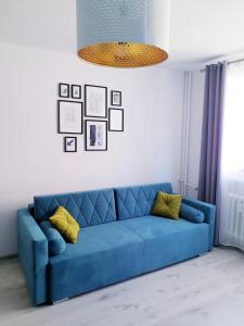 niebieska kanapa z żółtymi poduszkami w salonie w obiekcie Apartament Wałbrzych w Wałbrzychu