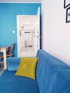 niebieska kanapa z żółtą poduszką w pokoju w obiekcie Apartament Wałbrzych w Wałbrzychu