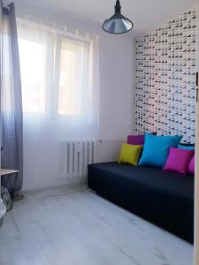 Pokój z kanapą z kolorowymi poduszkami w obiekcie Apartament Wałbrzych w Wałbrzychu