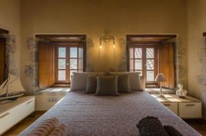 a bedroom with a large bed and two windows at Panthemis in Leonidio