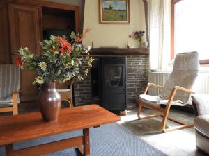 a living room with a vase of flowers on a table at Ancien relais de la diligence in Sart