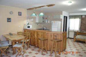 cocina con encimera de madera y mesa en Apart Bungalows Amulen en San Carlos de Bariloche