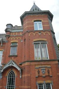 韦尔维耶克雷美小屋住宿加早餐酒店的红砖建筑,设有窗户和屋顶