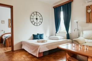 ein kleines Schlafzimmer mit einem Bett und einer Uhr an der Wand in der Unterkunft Ostarija Herbelier in Dolenjske Toplice