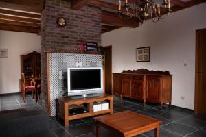 a living room with a television on a brick wall at Vakantiewoning Het Oude Laer in Bilzen