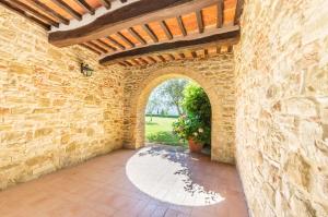 an archway in a stone building with a brick wall at Relais Borgo Torale in Passignano sul Trasimeno