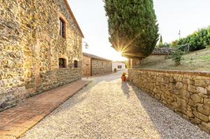 a stone building with a stone wall and a sidewalk at Relais Borgo Torale in Passignano sul Trasimeno