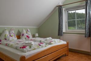una camera da letto con letto, cuscini e finestra di Chalet Ferienwohnungen a Brennberg