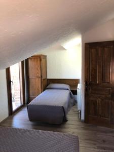 une chambre avec deux lits et une porte ouverte dans l'établissement casa de las Viñas 1 y 2, à Navaluenga 26 autres photos