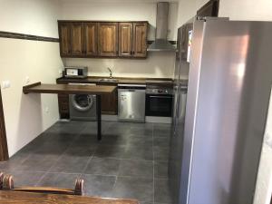 La cuisine est équipée d'un réfrigérateur en acier inoxydable et d'un lave-vaisselle. dans l'établissement casa de las Viñas 1 y 2, à Navaluenga