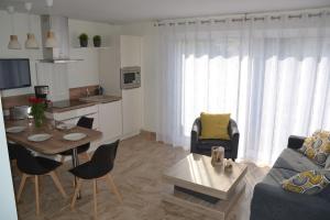 ein Wohnzimmer mit einem Sofa und einem Tisch in der Unterkunft Résidence Bel Air in Landerneau