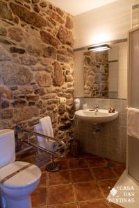 a stone bathroom with a sink and a toilet at Casa Rural as Bentinas in Milladoiro