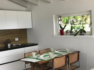 a kitchen with a table with chairs and a window at Villa Cà bianca in Torri del Benaco