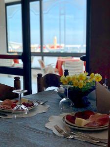 een tafel met borden eten en bloemen erop bij Hotel Silvana in Bellaria-Igea Marina