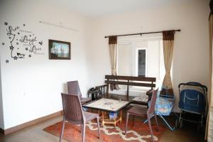 a living room with a table and chairs at Paradise Perfect in Ooty