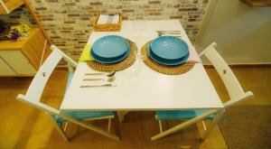 バレンシアにあるLa casita azul de la playaの白いテーブル(青い皿と調理器具付)