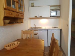 a small kitchen with a table and a microwave at Front de Neige Isola 2000 in Isola 2000