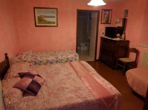 a hotel room with two beds and a television at Serenella B&B in Sestola