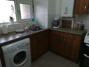 a kitchen with a washing machine and a sink at London budget Maisonette in London
