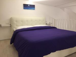 - une chambre avec un grand lit et une couverture violette dans l'établissement IL VIAGGIATORE VIA INDIPENDENZA 2, à Gaète