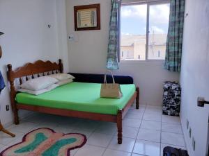 a small bedroom with a green bed and a window at wladinaldo barbosa cardoso in Salinópolis