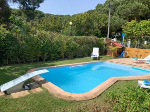 a swimming pool in a yard with two chairs at LV Premier Meco/Lagoa LA1 in Sesimbra