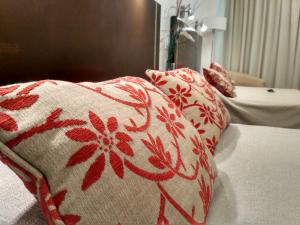 łóżko z czerwono-białymi poduszkami w obiekcie Palermo Bridge w BuenosAires