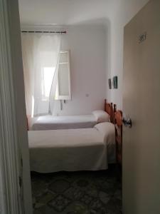 Łóżko lub łóżka w pokoju w obiekcie Hostal Sierpes
