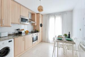 a kitchen with wooden cabinets and a table with chairs at Zubizarreko Etxea in Aizároz