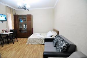 uma sala de estar com um sofá e uma cama em Apartment Albatross em Tbilisi