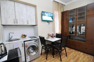 uma cozinha com uma mesa, um lavatório e uma máquina de lavar roupa em Apartment Albatross em Tbilisi