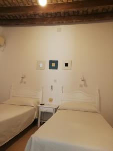 Łóżko lub łóżka w pokoju w obiekcie Hostal Sierpes