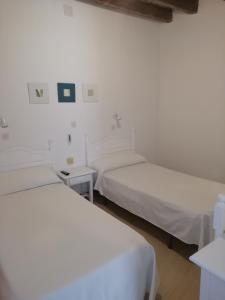Łóżko lub łóżka w pokoju w obiekcie Hostal Sierpes