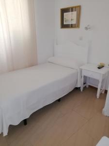 Łóżko lub łóżka w pokoju w obiekcie Hostal Sierpes