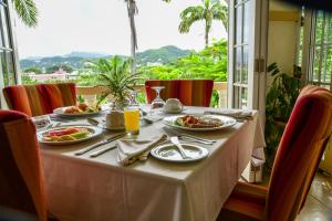 聖喬治的住宿－藍色地平線花園度假酒店，餐桌上放有食物盘子的桌子
