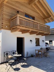 a balcony on a building with tables and chairs at Landhaus Wiesner - Gästezimmer - Bad - Bett - Kleine Kaffee - Tee-Theke mit Kühlschrank - Parkplatz in Rottach-Egern