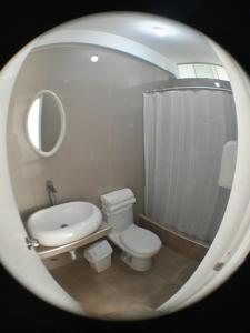 a bathroom with a toilet and a sink and a mirror at Residencial Maria Bonita in Paracas +18 photos