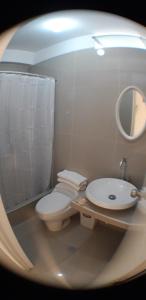 a bathroom with a toilet and a sink and a mirror at Residencial Maria Bonita in Paracas