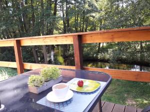 einen Tisch mit einem Teller Essen auf dem Deck in der Unterkunft Bobrowa Przystań in Czechyń