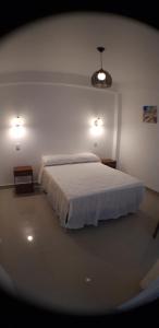 a bedroom with a white bed and two lights at Residencial Maria Bonita in Paracas